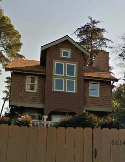 Google street view of a brown house with a fence.