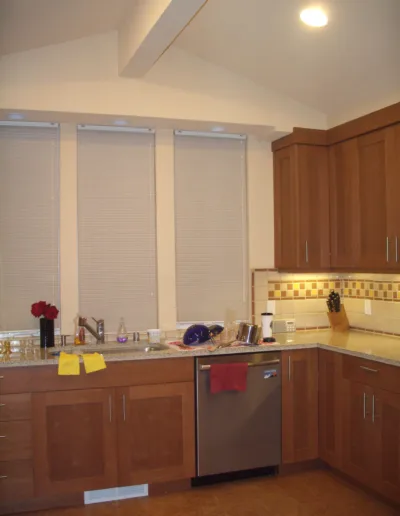 A kitchen with wooden cabinets and a stainless steel sink.