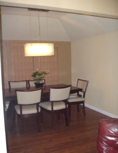 A dining room with a table and chairs.