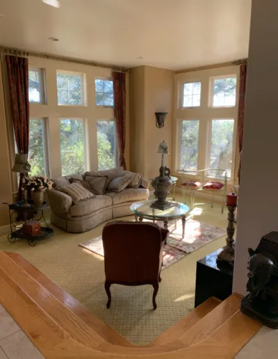 A living room with large windows and a couch.