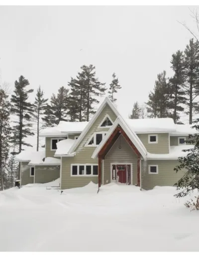 A home in the woods covered in snow.