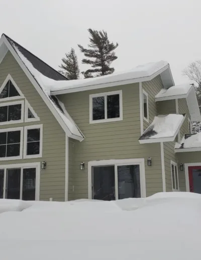 A home covered in snow with trees in the background.