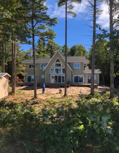 A house in the woods with trees surrounding it.