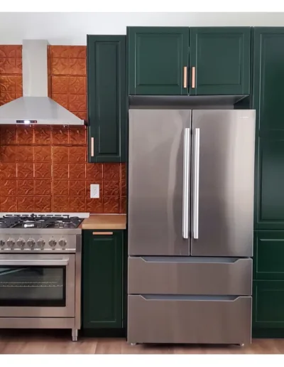 A kitchen with green cabinets and a stainless steel refrigerator.