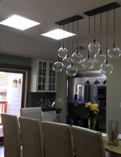 A dining room with a chandelier hanging over the table.